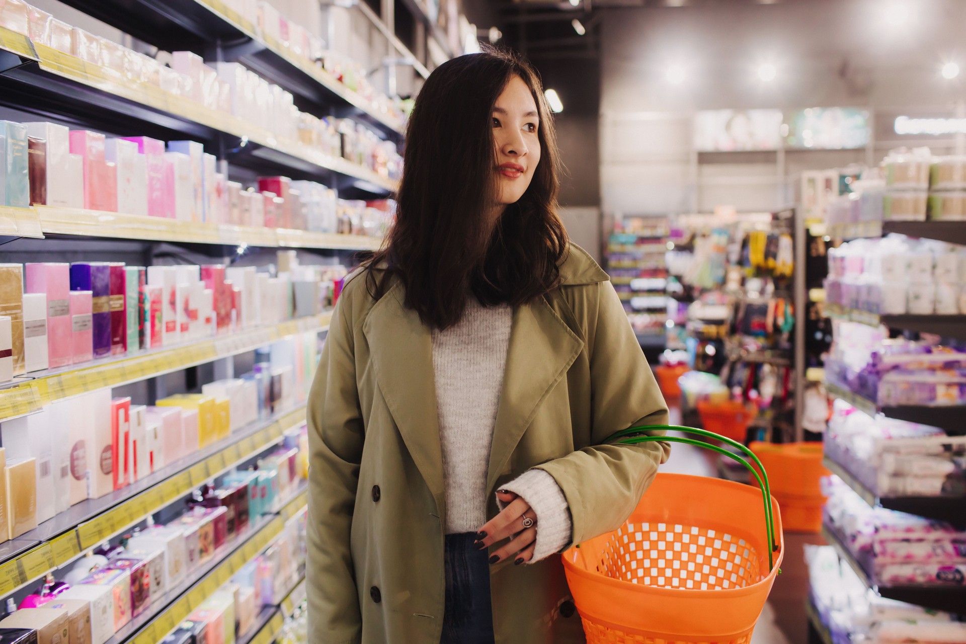 Young girl shopping in retail store. Beautiful teenage testing and buying cosmetics in a beauty store. Side view. Personal care and modern cosmetology. Beauty and fashion. Retail and consumerism.
